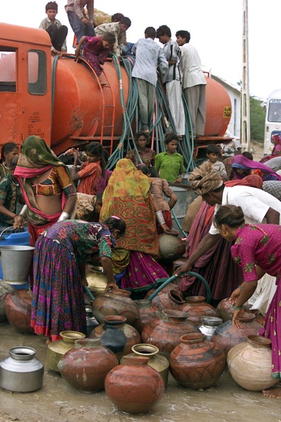 Indian tribal women fill drinking water in their pitchers in Banas Kantha village, Ahmedabad.