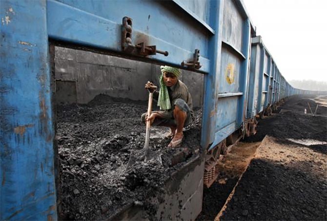 A worker unloads coal from a goods train at a railway yard in Chandigarh.