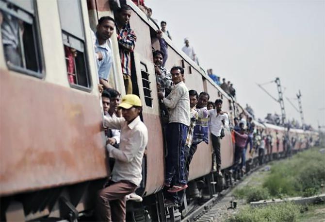 Passengers travel on an overcrowded train at Loni town in Uttar Pradesh.