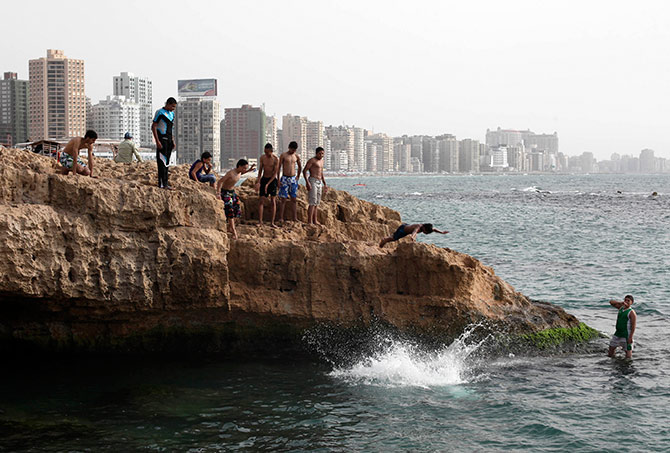 Youths jump into the sea to cool off on a hot day in the Mediterranean city of Alexandria.