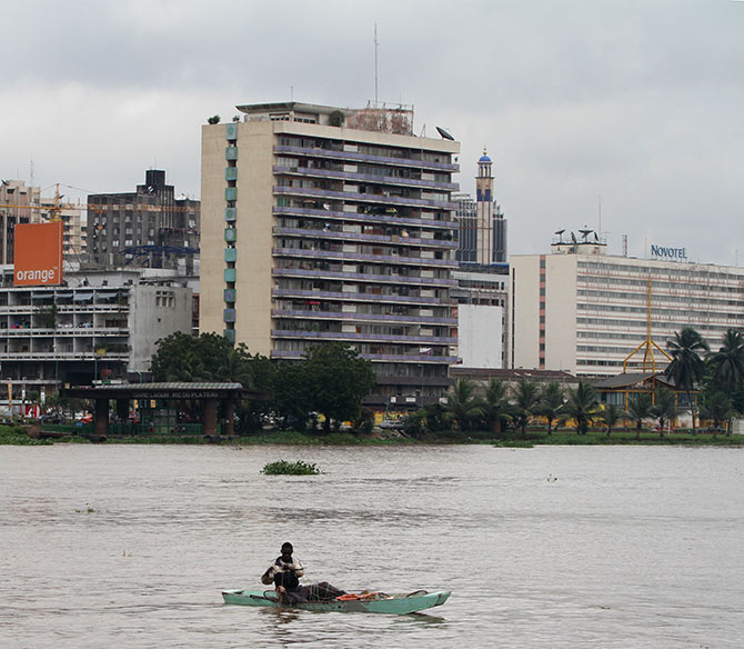 A man fishes in a boat on the Ebrie lagoon in Abidjan.