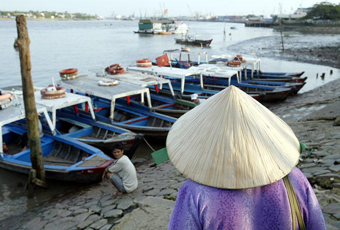 A Vietnamese woman prepares to board a small ferry used to shuttle commuters across the Saigon River near the port in Ho Chi Minh City.