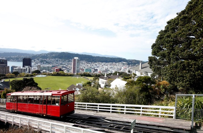 The Wellington Cable Car is seen ascending with a view of the city in the background.