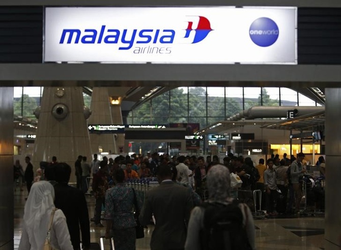 Passengers queue up at the Malaysia Airlines ticketing booth at the Kuala Lumpur International Airport in Sepang.