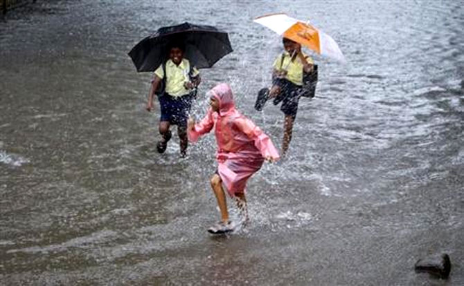 School children play on a flooded street during heavy monsoon rains in Mumbai.
