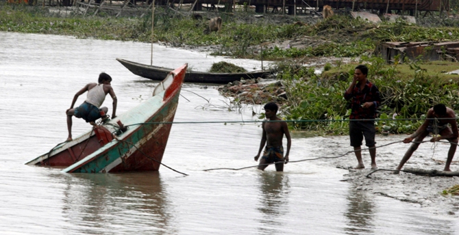 Workers try to retrieve a boat which sank in the Kirtankhola river during the storm at Barisal, 280km (174 miles) southwest of Dhaka.