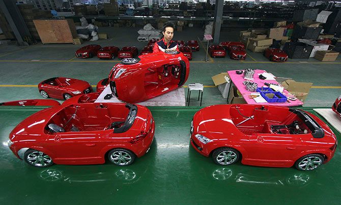 A worker assembles toy cars at a production line inside a factory in Jinjiang, Fujian province, China.