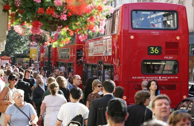 People prepare to board buses during the rush hour in central London.