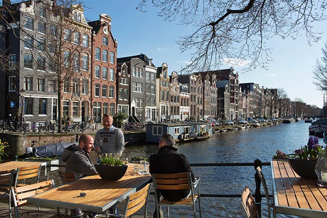 Men enjoy the afternoon sun at the Brouwersgracht canal in Amsterdam.
