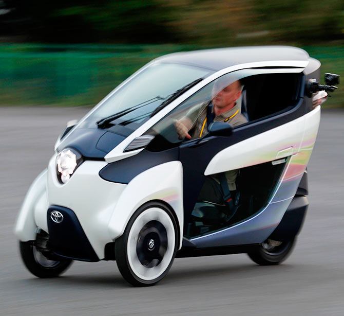 A journalist drives a Toyota ultra-compact, tandem two-seater electric vehicle i-ROAD during the Toyota Advanced Technologies media briefing in Tokyo.