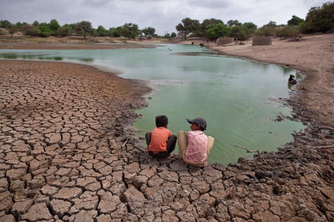 Children wash their hands in a partially dried-out natural pond at Badarganj village in Gujarat.