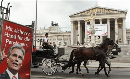 A traditional Fiaker carriage passes an election poster of Austrian Chancellor Werner Faymann of the social democrats (SPOe) in front of the parliament in Vienna September 4, 2013.