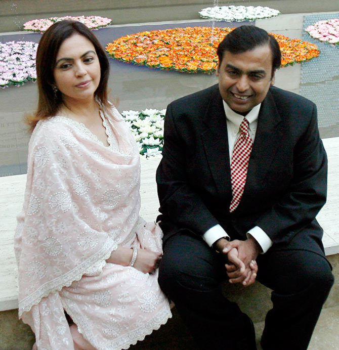 Mukesh Ambani (R), chairman of Reliance Industries, poses with wife Nita before a news conference in Mumbai.