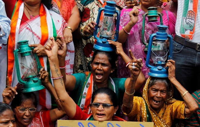 Demonstrators holding kerosene lanterns shout slogans during a protest against a power tariff hike, in Ahmedabad.