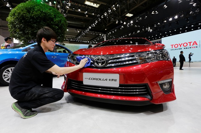 A man cleans a new Toyota COROLLA car at Auto China 2014 in Beijing, April 20, 2014.
