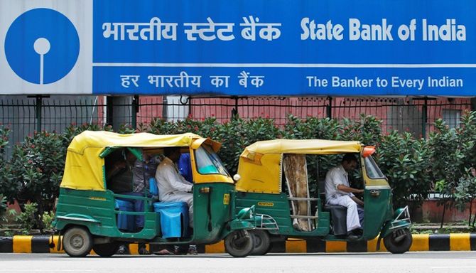 Auto rickshaws wait in front of the head office of State Bank of India (SBI) in New Delhi.