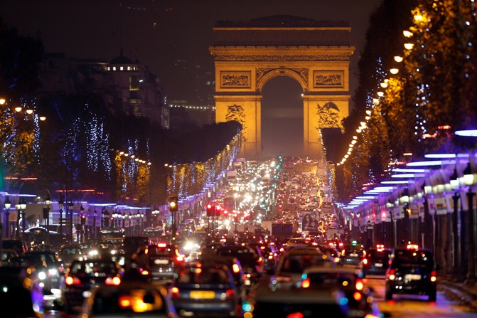 Christmas holiday lights decorate trees along the Champs Elysees with its Arc de Triomphe, in Paris.