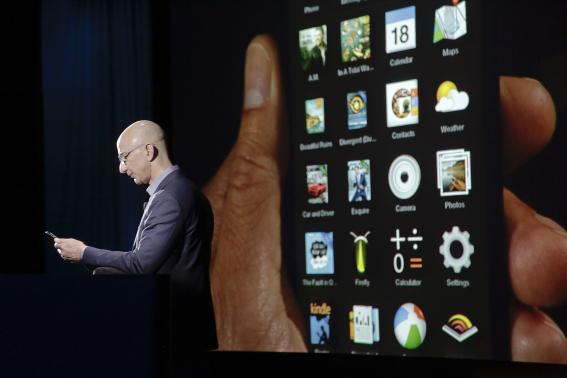 Amazon CEO Jeff Bezos shows off the 3D features of his company's new Fire smartphone at a news conference in Seattle, Washington