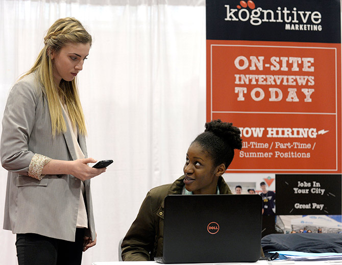 Kognitive Marketing recruiter Maggie O'Rourke (L) conducts a recorded on-site interview with Nafisah Amir (R) at the 2014 Spring National Job Fair and Training Expo in Toronto.