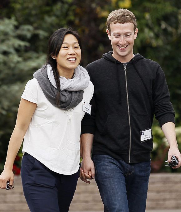 Facebook CEO Mark Zuckerberg walks with his wife Priscilla Chan.