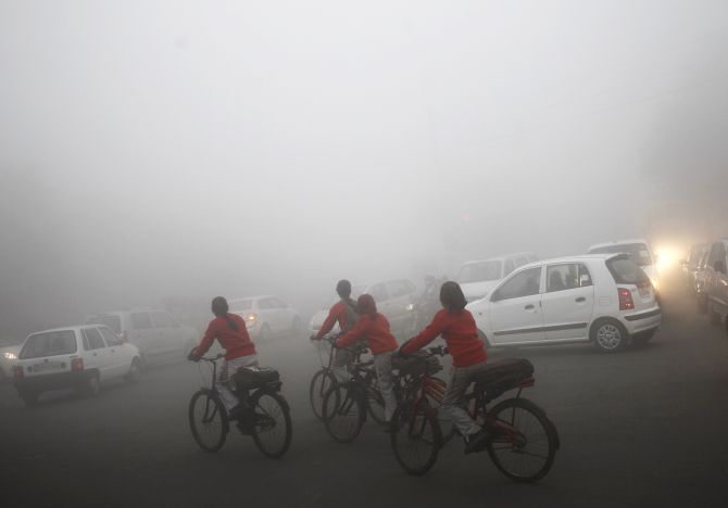 Commuters travel on fog covered roads on a winter morning in New Delhi.
