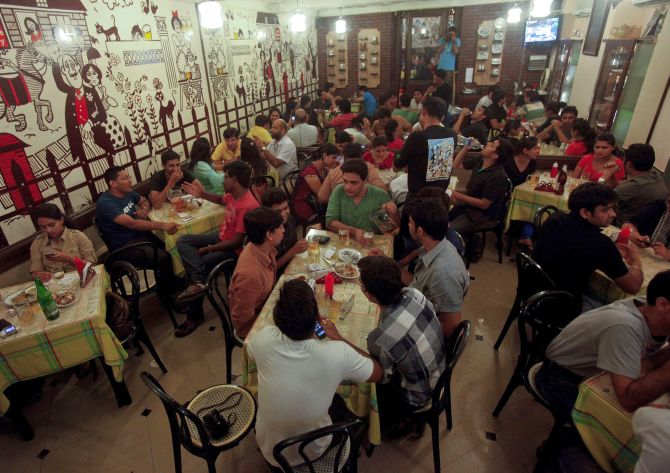 Patrons drink beer and eat food at a pub in Mumbai.