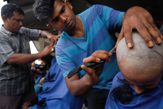A young female devotee shaves her head as part of the cleansing ritual during the Thaipusam festival.