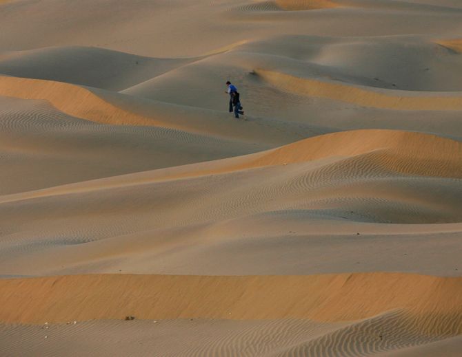 Tourists walk over the Thar Desert at Jaisalmer in the desert Indian state of Rajasthan.