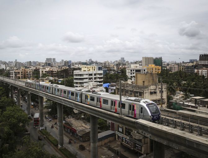A metro train travels through a residential area in Mumbai.