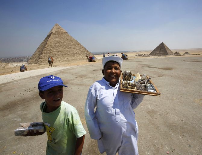Child vendors react as they attempt to sell souvenirs to tourists at the Giza Pyramids, on the outskirts of Cairo.
