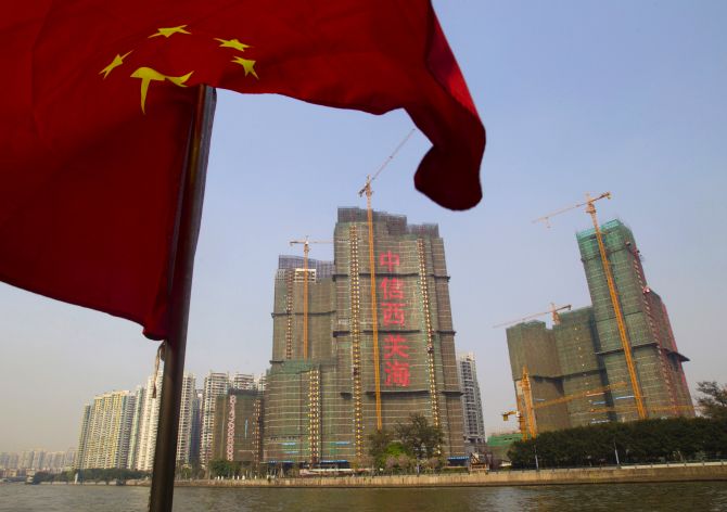 A Chinese national flag flutters on the Pearl River near a construction site in Guangzhou.
