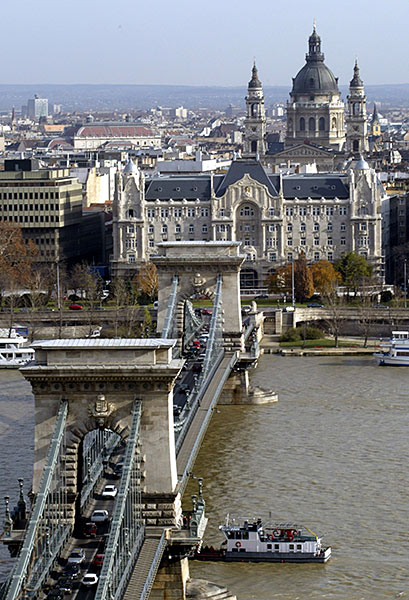 General view of Gresham Palace with Budapest's oldest bridge, Chain Bridge in the foreground and the St. Stephen Basilica in the background.