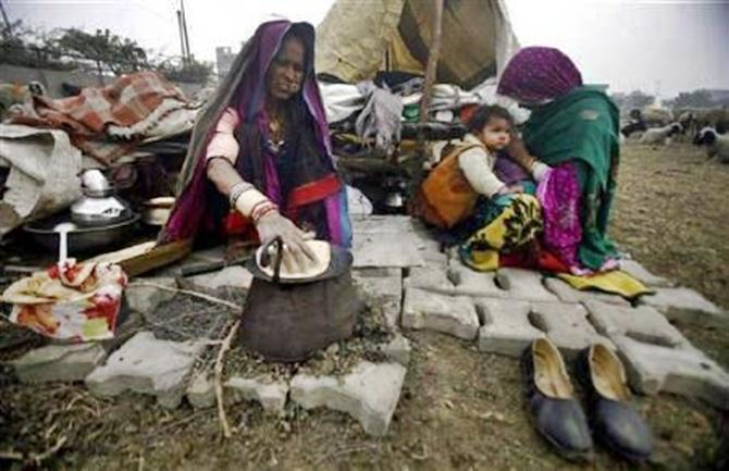 Women cook food outside a makeshift tent on a cold morning at Parthla village in Uttar Pradesh.