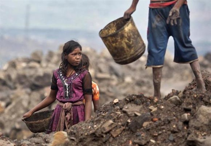 Locals prepare to collect coal from an open cast coal field at Dhanbad district in Jharkhand.