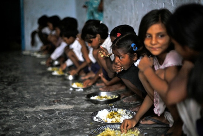 Schoolchildren eat their free midday meal, distributed by a government-run primary school, at Brahimpur village in Bihar.