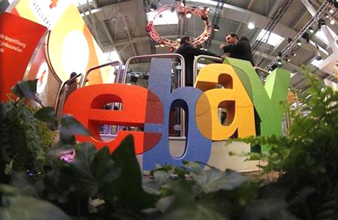 Visitors chat next to the Ebay logo at the CeBIT computer fair in Hanover.