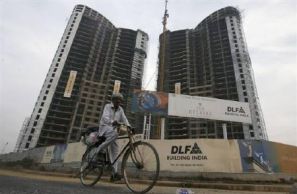 A passerby cycling in front of an under-construction building by DLF 