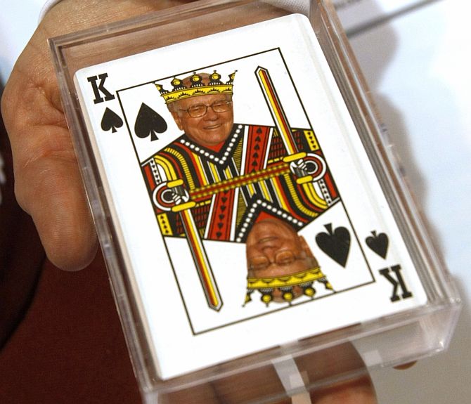 A woman displays playing cards for sale with a picture of Berkshire Hathaway Chairman Warren Buffett as the king of spades at a souvenir stand at the company trade show during the BH annual meeting in Omaha.