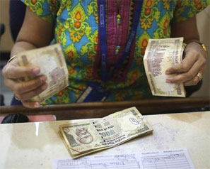 A cashier counts rupees inside a bank in Mumbai. Photograph: Danish Siddiqui/Reuters