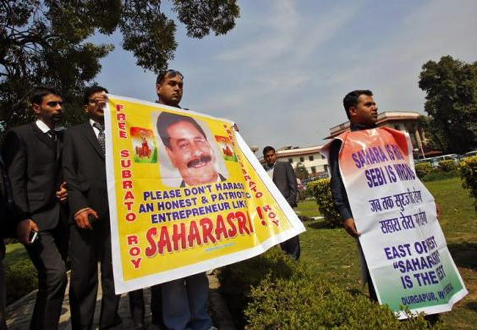 Supporters of the Sahara group chairman Subrata Roy holds banners in the premises of the Supreme Court as Roy appeared in the court.