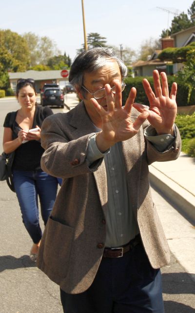 A man widely believed to be Bitcoin currency founder Satoshi Nakamoto is surrounded by reporters as he leaves his home in Temple City, California.