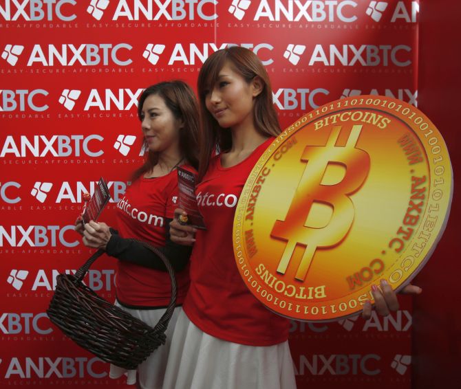Attendants pose with a bitcoin sign during the opening of Hong Kong's first bitcoin retail store.
