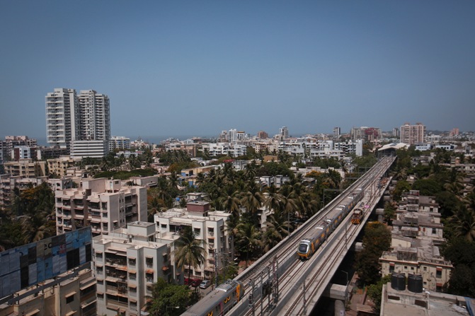 Metro trains pass through a residential area during its first official safety trial run in Mumbai. 
