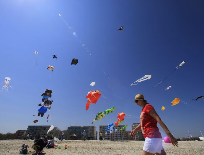 A woman strolls on the beach during Romania's first international Black Sea Kite Festival at the Black Sea resort of Mamaia, about 260 km (162 miles) east of Bucharest.