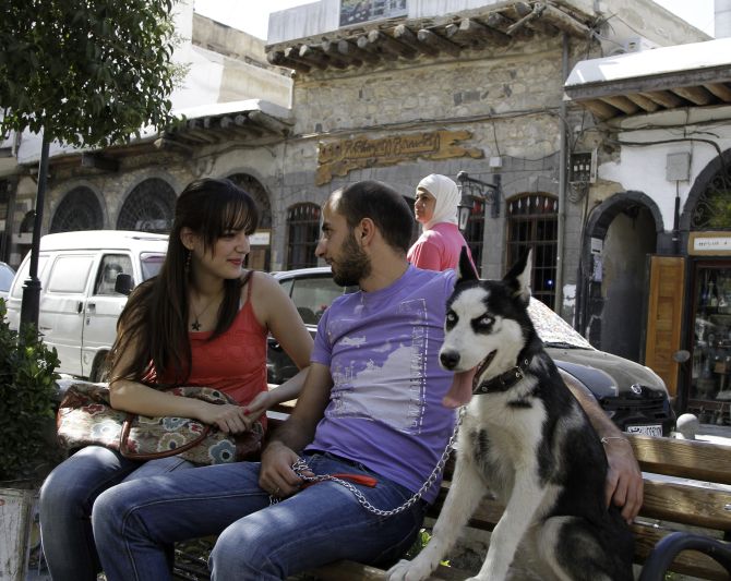 Syrian Christians sit in a park in Bab Touma, a Christian quarter of the Old City in Damascus.