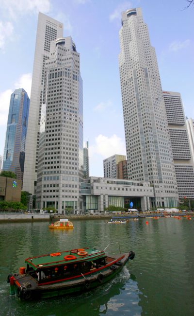 A boat on the Singapore river sails past office buildings in Singapore.