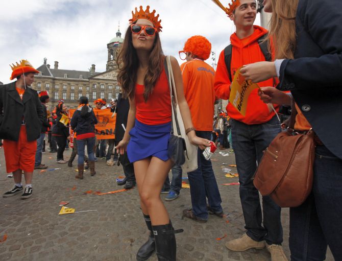 A woman celebrates the new Dutch King Willem-Alexander who succeeds his mother Queen Beatrix, in Amsterdam's Dam Square.