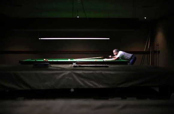 A member of the Shell Club, a sports and social venue, plays at a pool table near the Shell Oil refinery in Geelong.