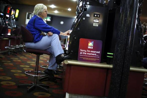 A visitor to the Shell Club, a sports and social venue, plays a slot machine near the Shell Oil refinery in Geelong.