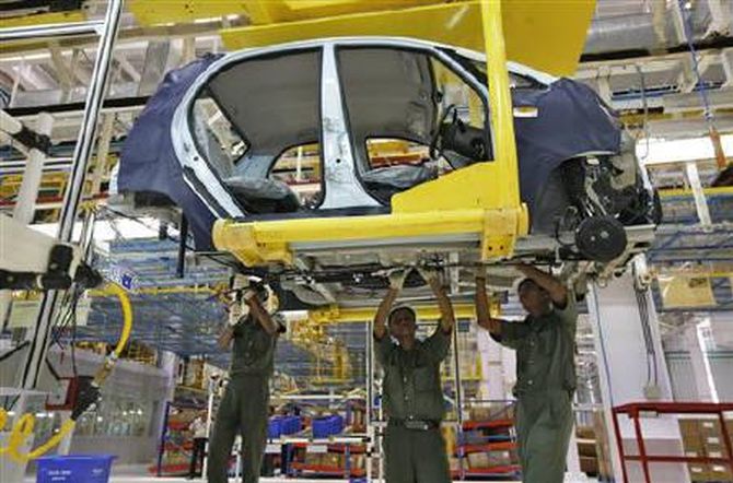 Employees work inside the plant for the Tata Nano car at Sanand in Gujarat June 2, 2010